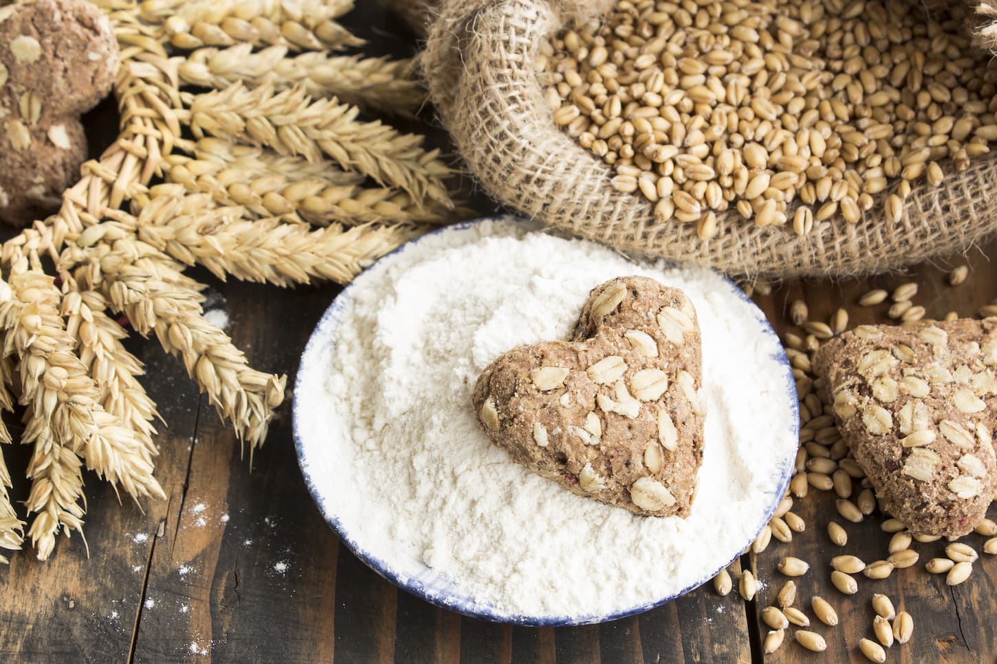 An image of wheat and wheat products on a rustic wooden background.