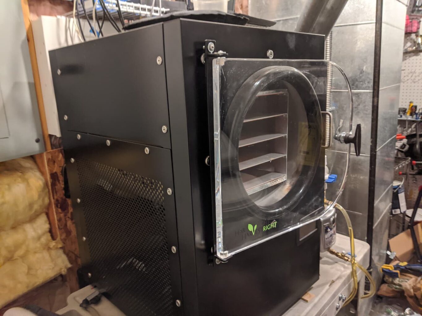 An image of a medium-sized black Harvest Right freeze dryer on a cart in a utility room