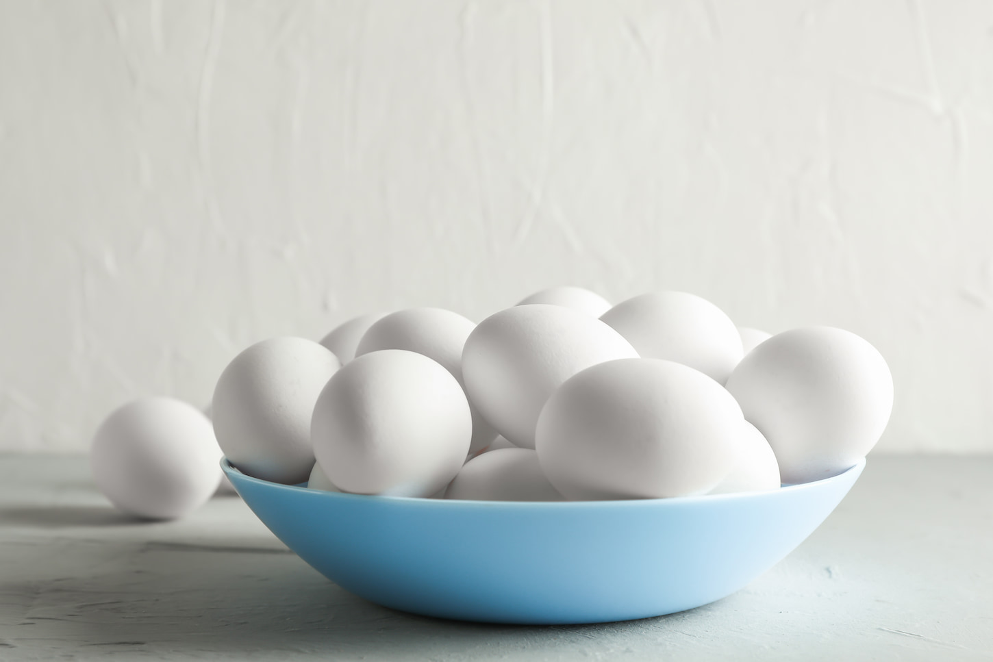 An image of Chicken eggs on a plate on the gray table against a white background.