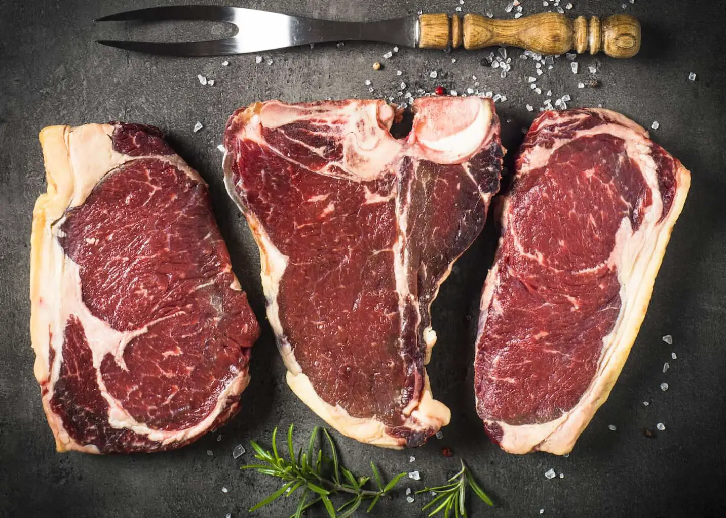 An image of a dry aged beef steaks in a gray background.