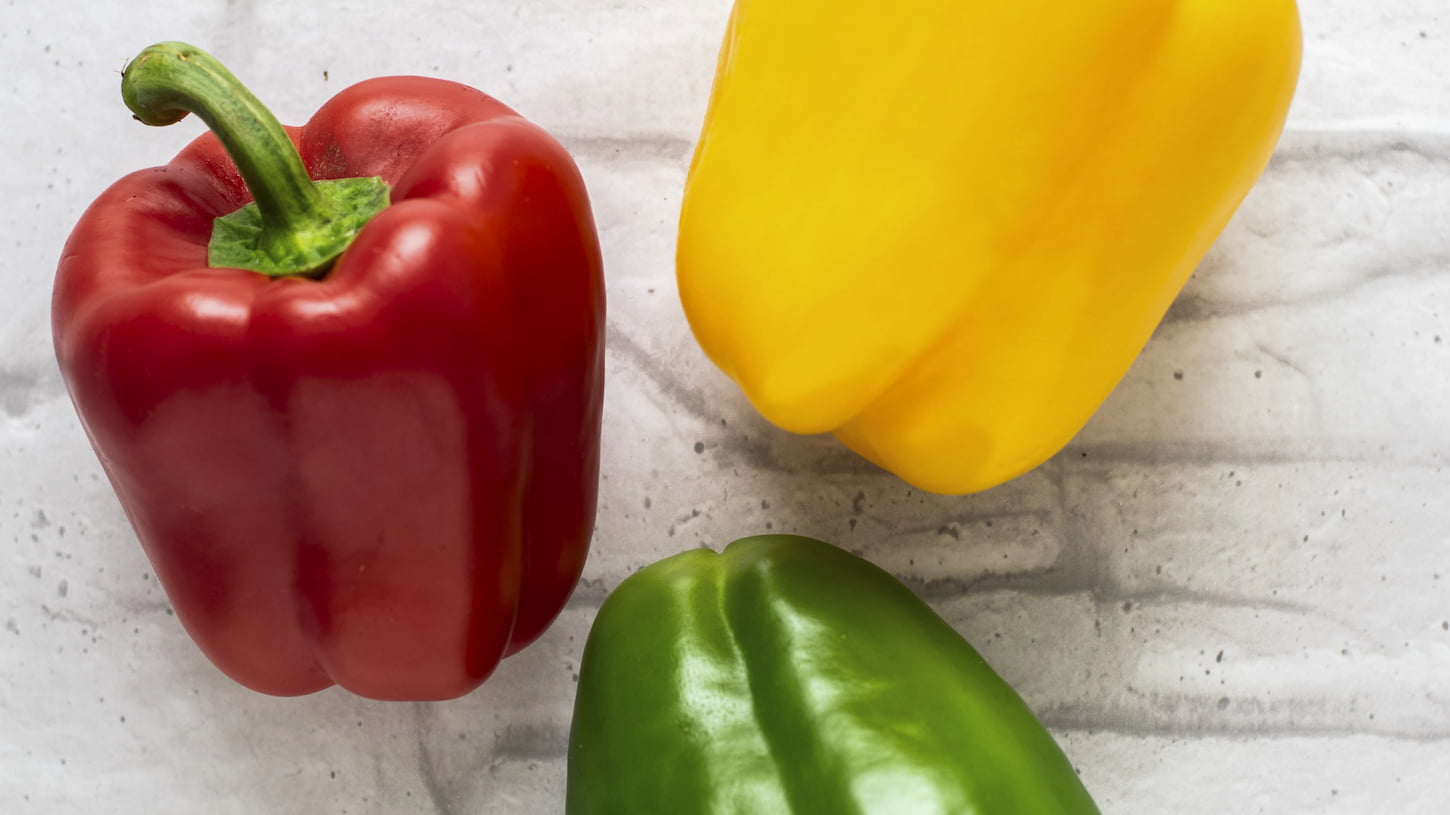 An image of yellow, green, and red bell peppers.