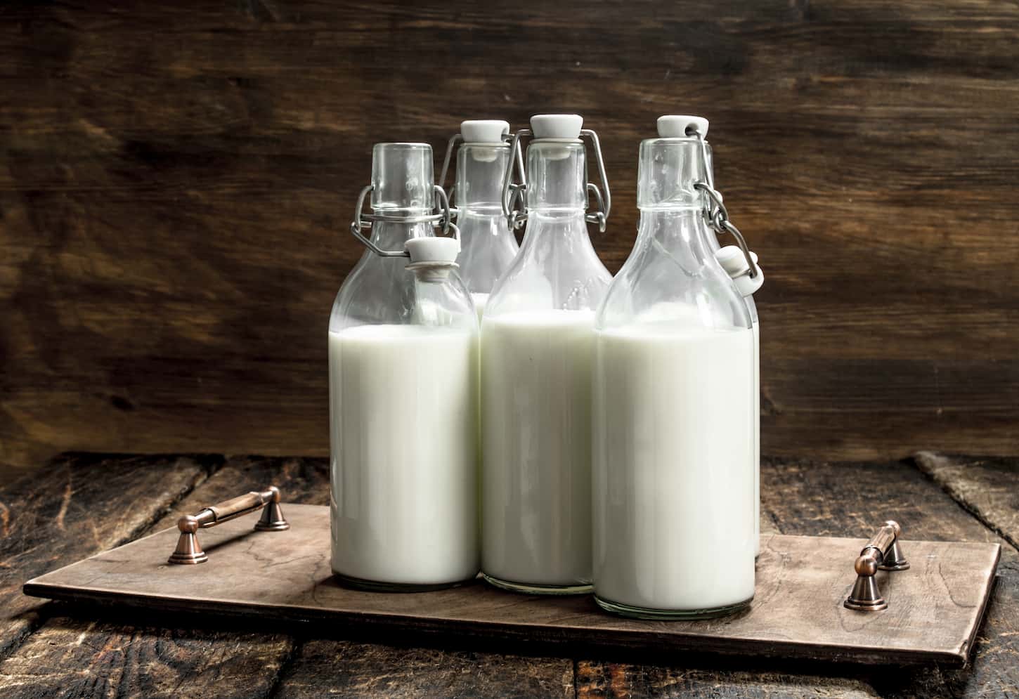 An image of Bottles with fresh milk on a wooden background.
