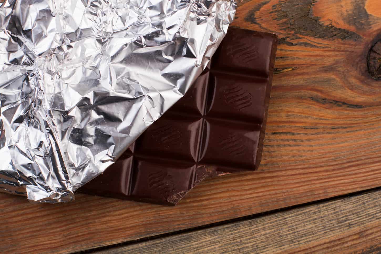 An image of a chocolate bar wrapped in silver foil.