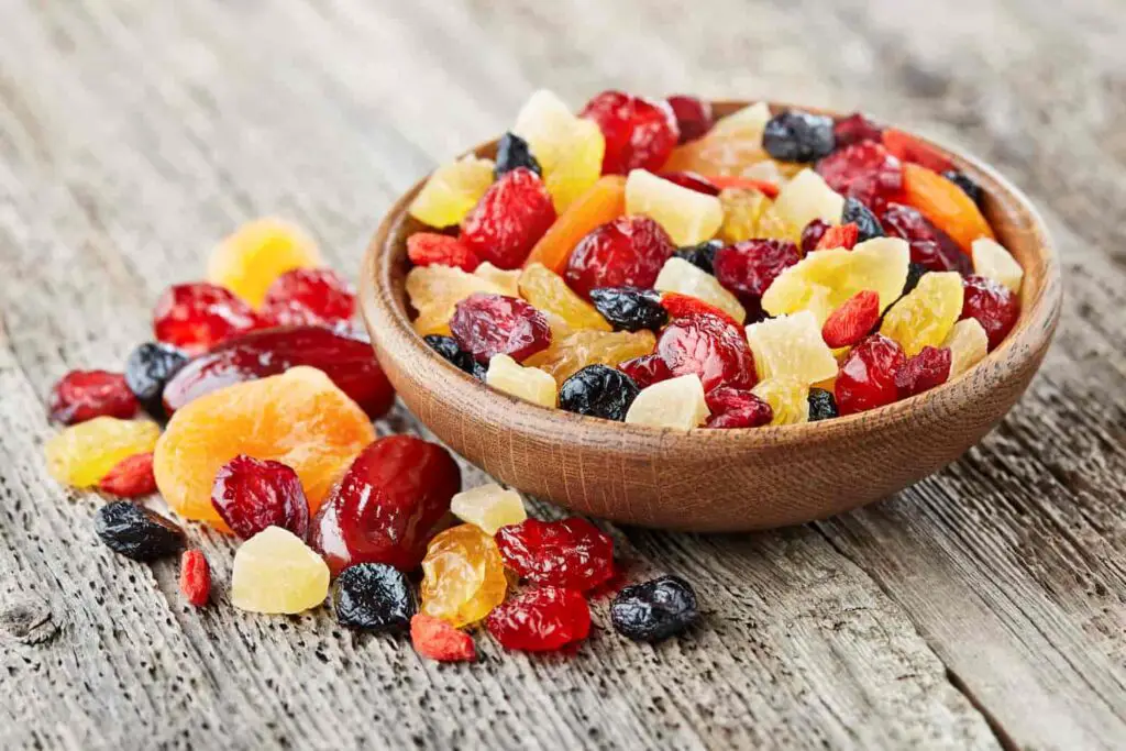 An image of dried fruits and berries in a wooden bowl.
