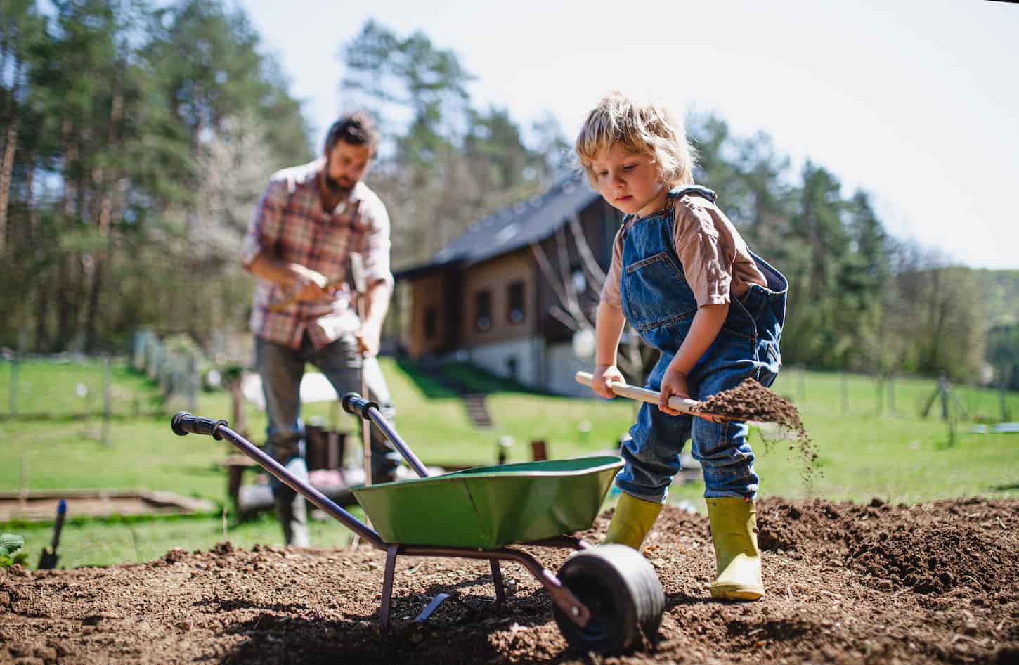 An image of a Father with a small son working outdoors in the garden, a sustainable lifestyle concept