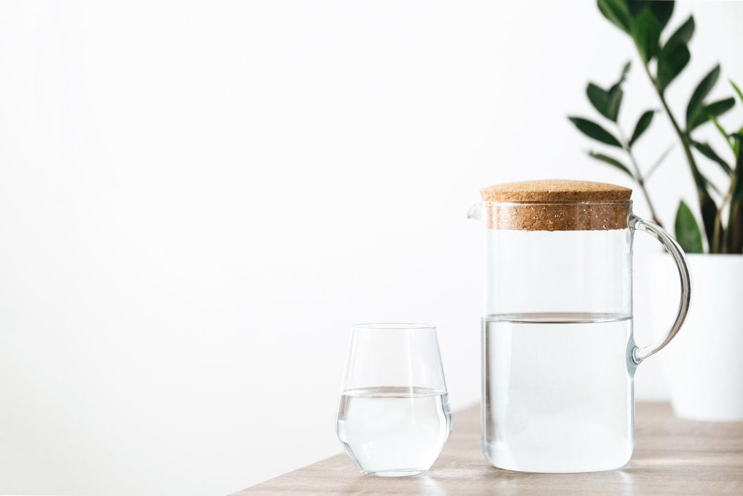 An image of a glass of water and jar on a white and clean background.