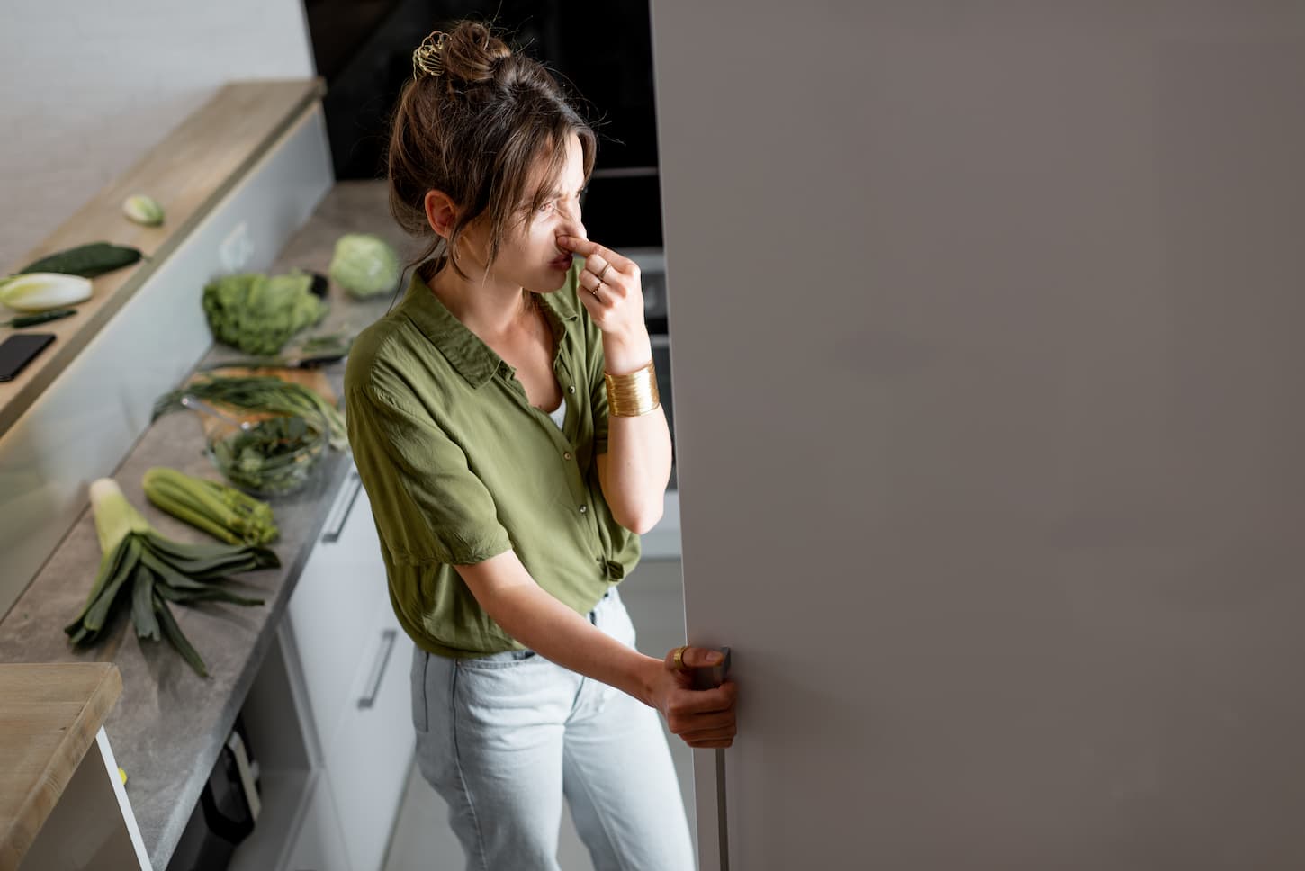 An image of a Woman looking into the fridge in the kitchen at home.