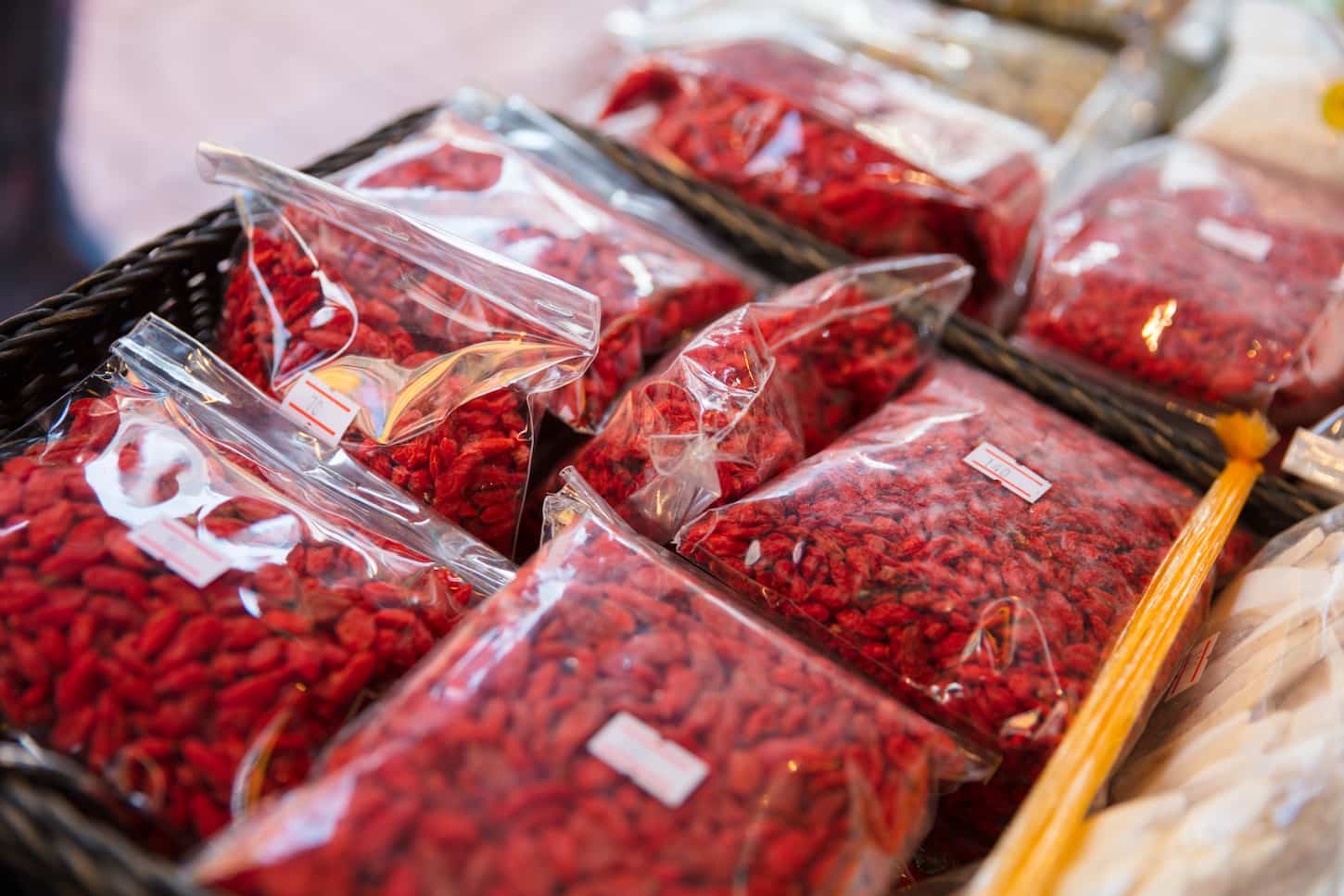 An image of Dried Goji Berries In Plastic Bags At a Local Market.