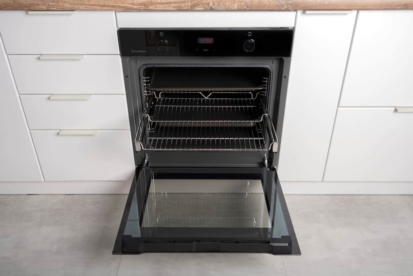 An image of a New modern electric oven built in black with screen, convention and grill, empty and open.