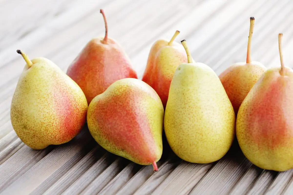 An image of ripe pears on a wooden, corrugated type of background.