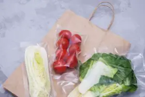 An image of Tomatoes, lettuce leaves and Peking cabbage in a vacuum package.