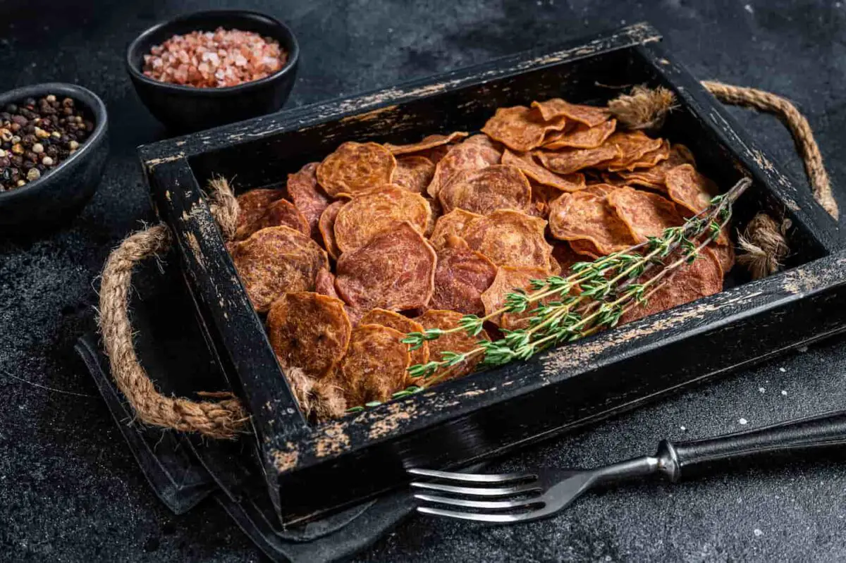 An image of Cured Beef and pork Jerky meat in a wooden tray.