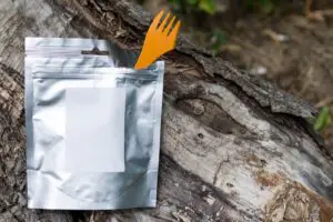 An image of a mylar bag on a log with an orange fork